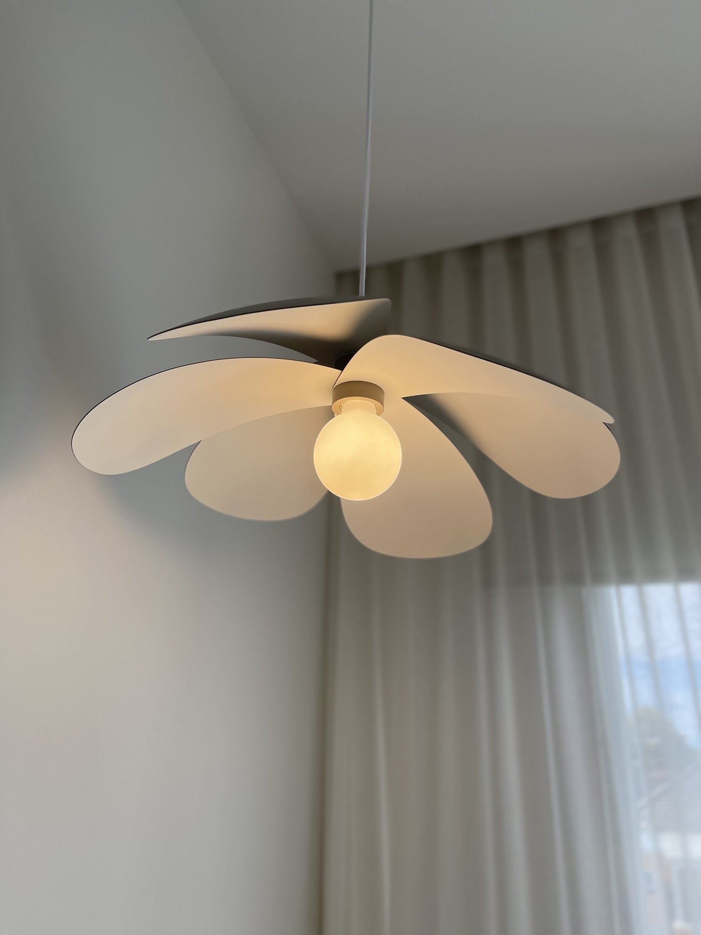Petal-shaped pendant light with an exposed globe