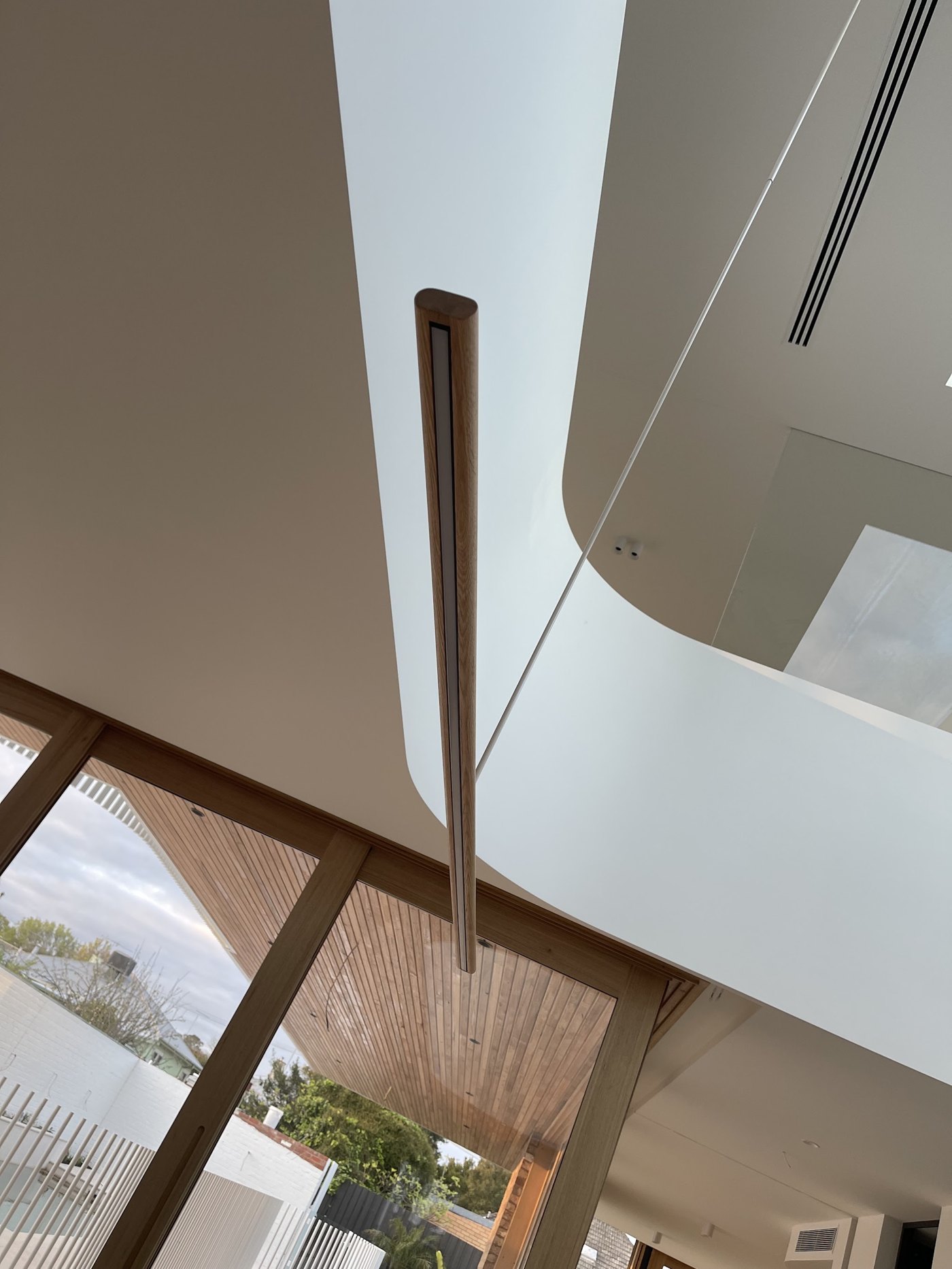 Timber and LED strip pendant hanging in a double-height void