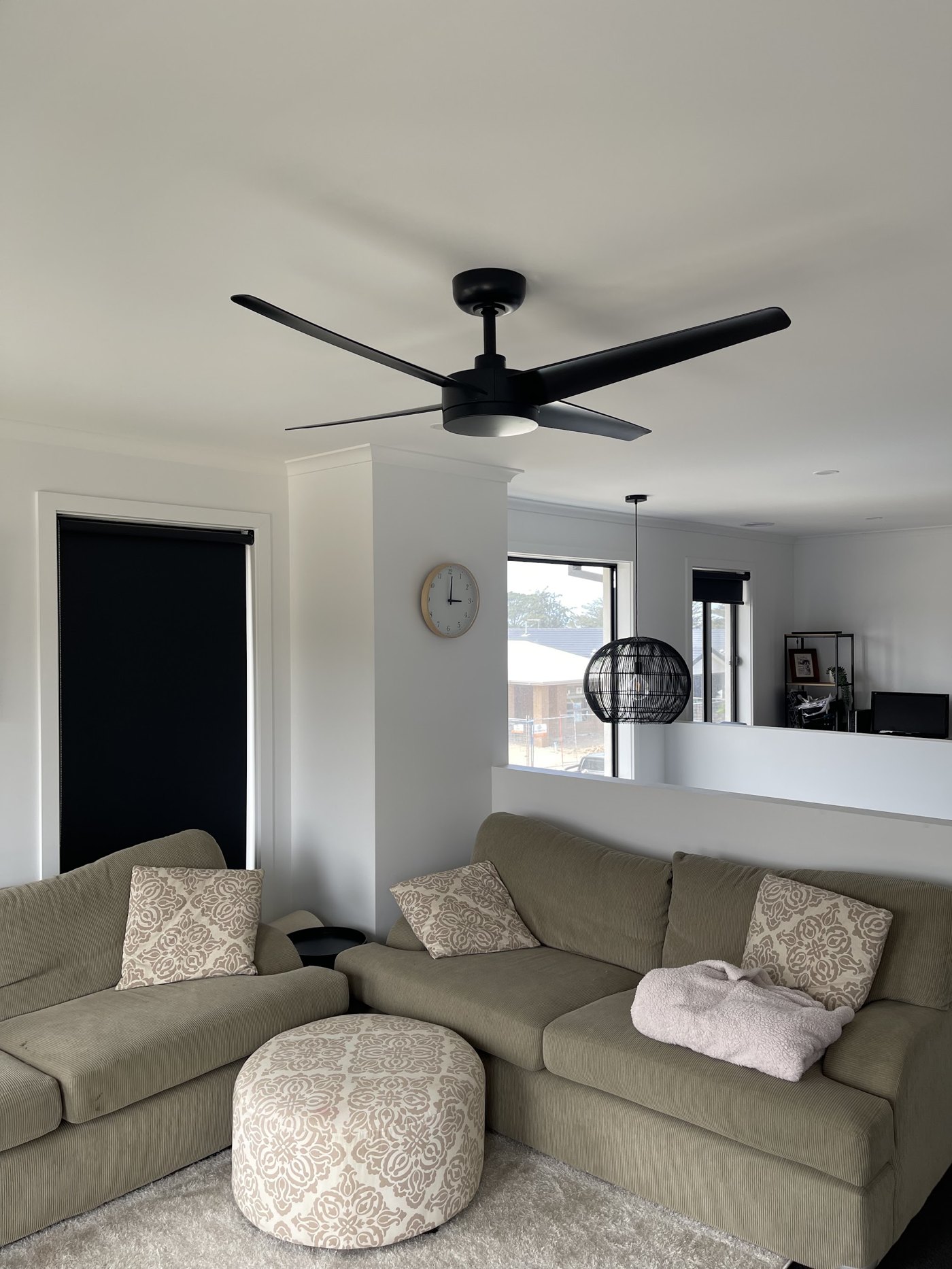 Black four-blade ceiling fan with light in a living room