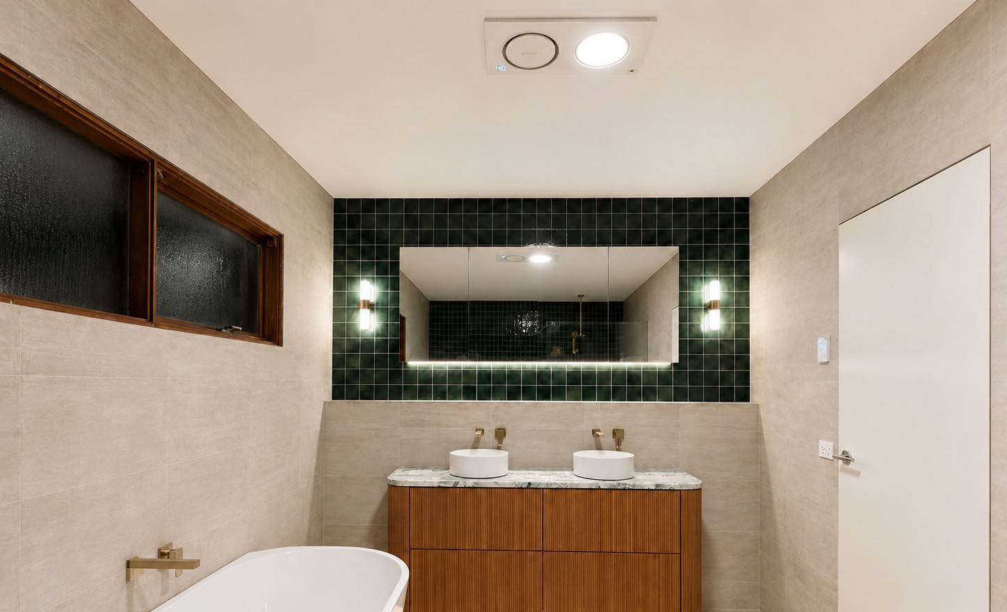 Bathroom with downlights, backlit mirror, wall lights and a lit strip under the vanity